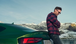 Man stands behind his Audi RS5 in the alps