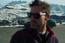 Male model stands in front of Audi RS5 in the alps