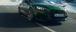 Audi RS5 driving on a mountain road with snow